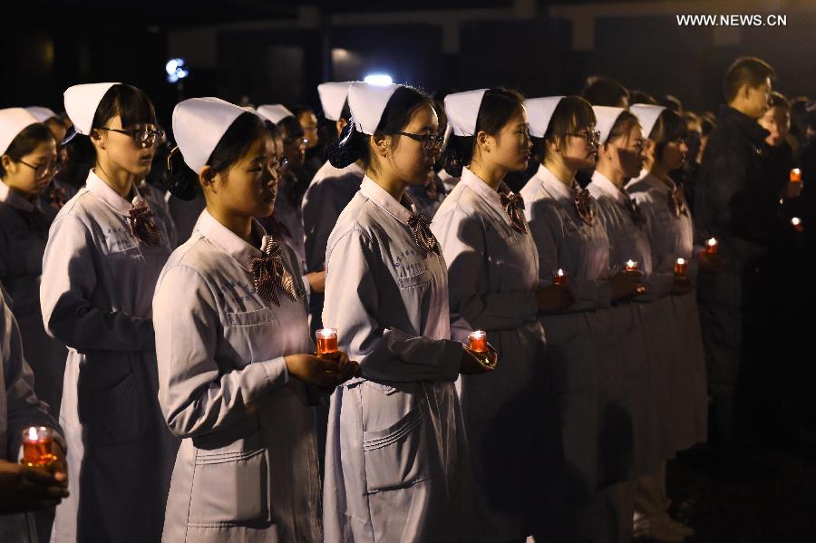 People hold candles to mourn victims of Nanjing Massacre