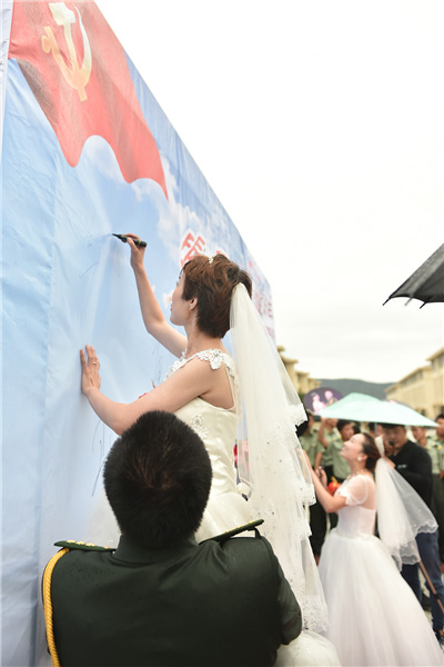 Couples exchange 'bullet shell rings' at group wedding in military camp