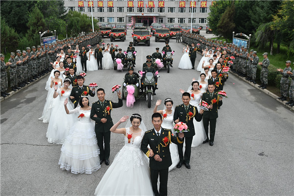 Couples exchange 'bullet shell rings' at group wedding in military camp