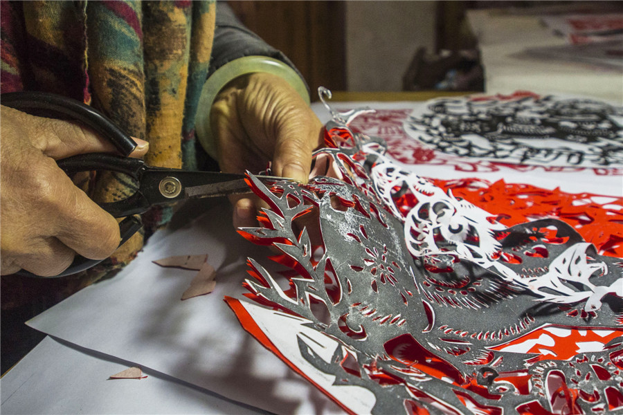 Students create paper-cut art in E China