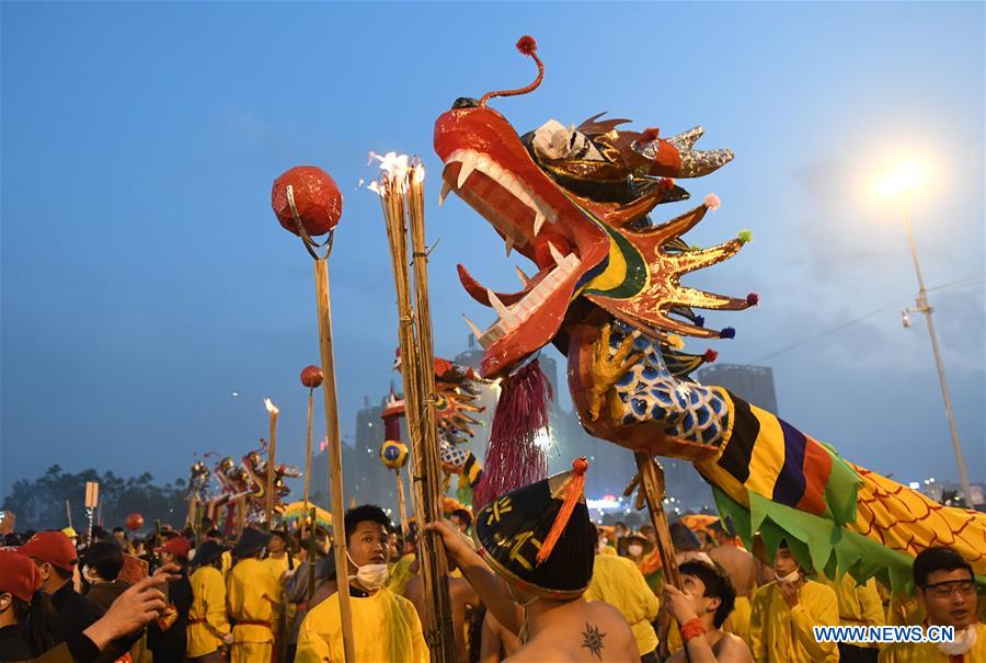 People perform dragon dance in flames of firecrackers in Guangxi