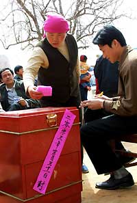 A villager casts her vote at Datan Village in Lanzhou's Xigu District, Gansu Province. Grassroots democracy has improved vastly, thanks to NPC's efforts. [newsphoto/file]