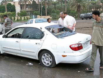 An Iraqi youth surveys the scene of the assassination of the deputy governor of Baghdad, Hatem Karim, who was killed and two of his bodyguards were wounded in a drive-by shooting in the southern Dora district of the Iraqi capital, November 1, 2004. Gunmen assassinated the deputy governor of Baghdad on Monday, a day after Iraq's U.S.-backed interim prime minister spoke of an imminent military showdown with rebels in the western city of Falluja. [Reuters]