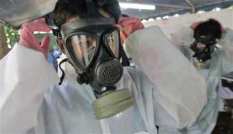 Volunteers wear protective masks and clothing Saturday, Jan. 1, 2005, in preparation for handling the corpses of those killed in the Patong Beach area in last weeks tsunami wave. The death toll in Thailand from last weeks tsunami is over 4,500, more than half of those are foreigners with an additional 6,000 still missing. (AP 