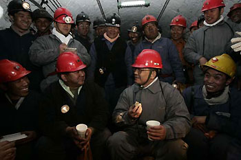 Premier Wen Jiabao has lunch with on-duty miners on the new year's day in the coal mine shaft, about 1,300 meters underground. [Xinhua]