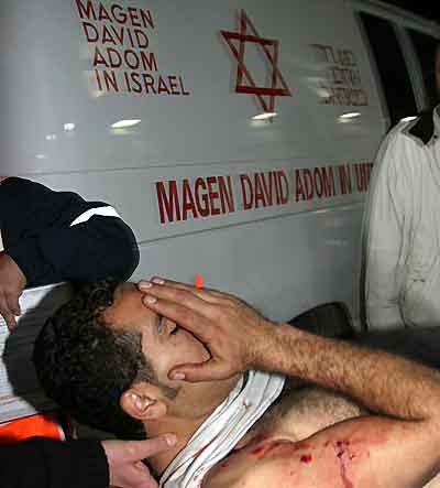 A wounded man is brought by ambulance attendants to a hospital in the southern Israel city of Beersheva January 13, 2005. Five people were killed when Palestinians mounted an attack near an Israeli army base in Gaza on Thursday, witnesses and radio stations said, hours after the Palestinians' new leader called for an end to violence. In the biggest such attack since the election of moderate Mahmoud Abbas as Palestinian president on Sunday, a huge bomb went off outside the Karni crossing between Israel and the Gaza Strip, Israeli radio said. [Reuters]