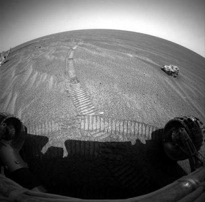 In this image released Tuesday, Jan. 18, 2005, by NASA taken by the Mars rover Opportunity, a basketball-size metal meteorite can be seen in the upper right of the image while part of the rover's heatshield is seen to the upper left. [Reuters]