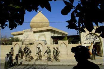 U.S. soldiers from the 1st Battalion, 24th Infantry Division walk past in front of a mosque during a house-by-house search looking for illegal weapons, in northern Iraqi city of Mosul, 370km of Baghdad. Militants freed eight Chinese hostages but said in a website that they had slain 15 Iraqi soldiers being held captive, after at least 27 people died in two car bomb attacks aimed at Iraq's Shiite majority. [AFP]