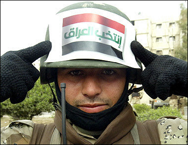 An Iraqi soldier holds a leaflet that reads 'Vote for Iraq' outside a polling station in the Salhiyah district of Baghdad. [AFP]