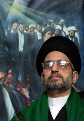 Abdul-Aziz al-Hakim, the Shiite alliance's leader, walks out of his office past a painting showing his older brother and his brother's followers before he was assassinated in Najaf by a car bomb in 2003, in Baghdad, Iraq Wednesday, Feb. 16, 2005. [AP]