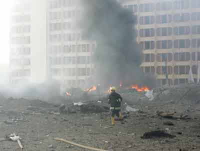 An Iraqi fireman responds to the scene after a powerful suicide bomb exploded in central Baghdad early March 9, 2005. A suicide bomber driving a garbage truck blew himself up on Wednesday near a Baghdad hotel used by Iraqi police and their foreign instructors, police said, shaking buildings and sending thick black smoke into the sky. [Reuters]