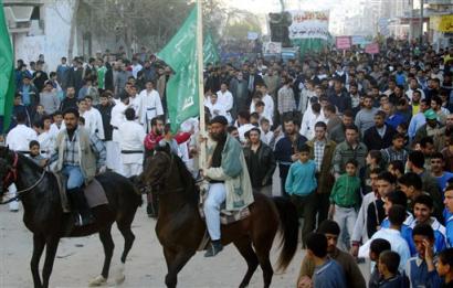 Palestinian Hamas supporters ride horses as others march, during a rally along the streets of Sheik Radwan neighborhood in Gaza City, Friday March 18, 2005. The 13 main Palestinian militants groups have announced that they would halt attacks on Israel for the rest of the year, the longest-yet period of promised calm and a success for Palestinian leader Mahmoud Abbas. [AP]