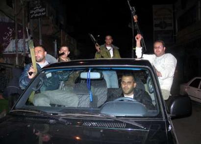 Palestinian militants from the al-Aqsa Martyrs Brigade hold rifles as they celebrate in the West Bank city of Tulkarm March 21, 2005. Israel handed over security control of the West Bank city of Tulkarm to the Palestinians Monday, a Palestinian security official said. REUTERS/Mustafa Abu Dayeh