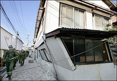 Japanese soldiers walk past a damaged house in Genkai island in southern Japanese city of Fukuoka, a day after a strong earthquake which measuresed 7.0 on the Richter scale. A series of aftershocks rattled Japan's southern Kyushu island, two days after a powerful earthquake left one dead and more than 700 injured, officials said.(AFP/JIJI Press) 