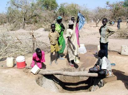 Displaced Sudanese from the Darfur region fetch water from a wadi (water well) in Aweil, Southeast of Sudan capital Khartoum, February 19, 2005. The U.N estimates there are more than 2 million people living in the camps outside Khartoum. REUTERS/Str 