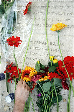 A person puts a flower on Yitzhak Rabin's grave at Mount Hertz cemetery in Jerusalem in 2003.[AFP/File]