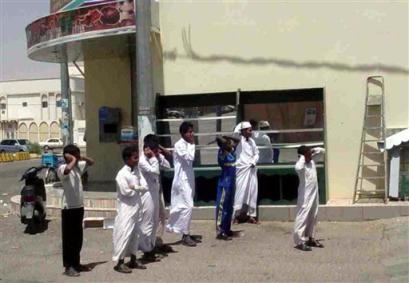 Saudi boys cover their ears as they crowd to watch clashes at al-Rass,( 355 kilometers ) 220 miles northwest of the capital, Riyadh, Saudi Arabia Tuesday, April 5, 2005 where a three-day shootout between Saudi security forces and suspected Islamic extremists reportedly left 14 armed extremists dead . (AP Photo 