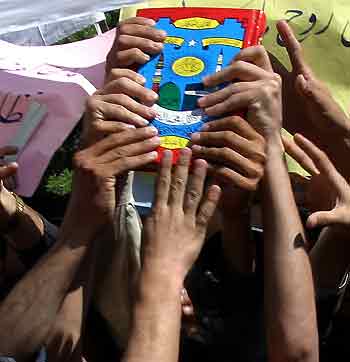 Afghan university students try to touch a copy of the Koran during a protest in Kabul May 12, 2005. [Reuters]