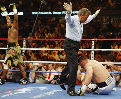 World Boxing Organization champion Lamon Brewster (L) celebrates as referee Gino Rodriguez (C) ends the bout against Andrew Golota during the first round of their World Boxing Organization heavyweight title fight in Chicago May 21, 2005. Brewster won by technical knock-out 53 seconds into the first round. [Reuters]