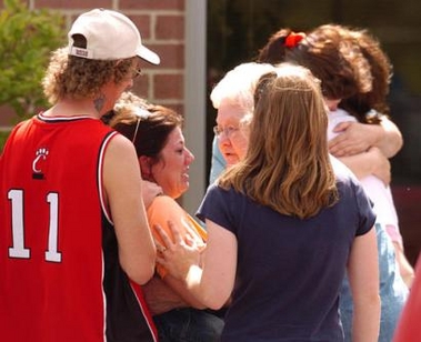 A group of unidentified people react outside of the Logan County, Ohio, sheriff's office to the news that six people were found dead and one person wounded at a farmhouse west of Bellefontaine, Ohio, Sunday, May 30, 2005. 