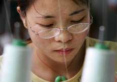 A Chinese worker sew T-shirts in a garment factory in Dongguan in south China's Guangdong province May 27, 2005. The European Union started a 15-day clock ticking on possible Chinese textile import curbs on Friday but held out hope for a 'mutually satisfactory' agreement with Beijing despite advancing the May 31 deadline for action. The EU Executive Commission, in charge of trade policy in the 25-nation bloc, said intensive talks would take place starting on Monday at all levels with China over its surging textile exports. Picture taken on May 27, 2005. 