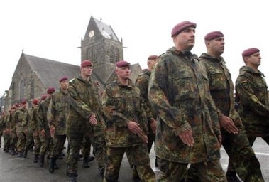 German parachutists walks past the church at Sainte-Mere-Eglise, northern France, Sunday, June 5, 2005, during ceremonies to commemorate the Allied D-Day landings of World War II. 