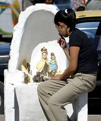 A woman prays in Huara town, some 96 km (59 miles) off Iquique, about 1,845 km (1,146 miles) north of Santiago, Chile, June 14, 2005. [Reuters]