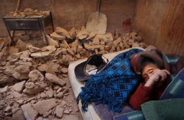 Juana Garcia, 104, sleeps between debris at her damaged residence in Huara, some 96 kilometers (60 miles) from Iquique port City in Chile, Tuesday, June 14, 2005, after an earthquake of 7.9 magnitude struck killing at least a dozen people. (AP