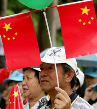 Members of pro-China communities in Hong Kong carry Chinese national flags as they take part in a parade marking the eighth anniversary of the handover of the former British territory to Chinese rule, July 1, 2005. 