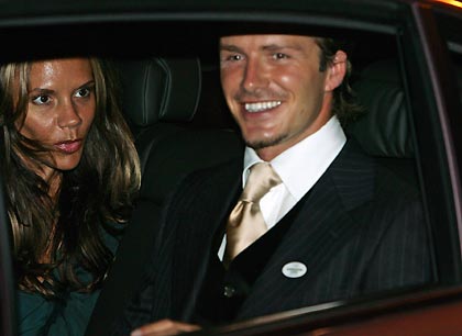 England's soccer captain David Beckham (R) and his wife Victoria leave a dinner reception at the British High Commissioner's residence in Singapore July 4, 2005. [Reuters]