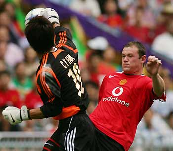 Manchester United's Wayne Rooney (R) is stopped by Hong Kong goalkeeper Fan Chun-yip during the first half of their match in Hong Kong July 23, 2005. The English Premier League played their first match on Saturday as part of their Asian tour to China and Japan. 