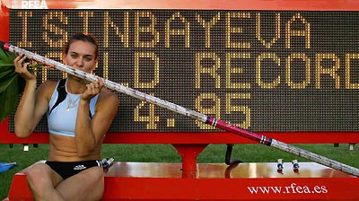 Russian pole vaulter Yelena Isinbayeva poses in front of a scoreboard after setting a new women's pole vault world record at the IAAF Super Grand Prix athletics meeting in Madrid, July 16, 2005.