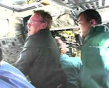 Astronauts Andy Thomas (L) of Australia and Soichi Noguchi (R) of Japan work with the shuttle Discovery's robotic arm orbital boom sensor system as they prepare to inspect the shuttle's nose and wing leading edges after a launch in which falling debris brought worrisome reminders of the Columbia disaster two years ago July 27, 2005. The image is from a sequential still video camera aboard Discovery's flight deck.