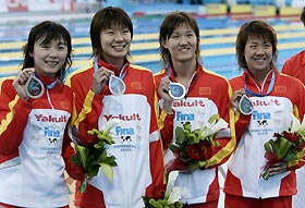 Members of the Chinese women's swim team hold up their bronze medals won in the women's 4 x 200m freestyle final at the World Aquatic Championships in Montreal July 28, 2005.