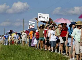 Dozens of women march with a giant letter addressed to U.S. first lady Laura Bush along a road towards the ranch of vacationing U.S. President George W. Bush in Crawford, Texas, August 18, 2005. Dozens of letters, addressed to first lady Bush appealing for her compassion to influence President Bush, were handed to White House representative Bill Burck after the women marched to a police checkpoint near the ranch. [Reuters]