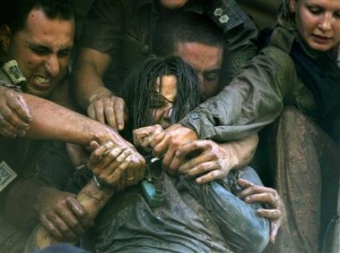 Israeli security forces scuffle with a resisting Jewish settler during the evacuation of the northern West Bank Jewish settlement of Homesh, Tuesday Aug. 23, 2005.