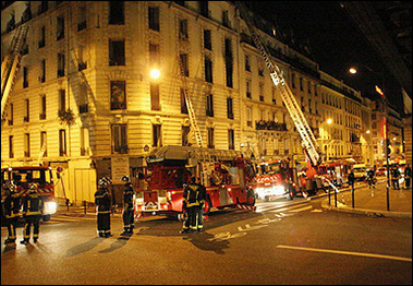 Firemen evacuate victims after a blaze ripped through a dilapidated apartment building in Paris, 26 August 2005.