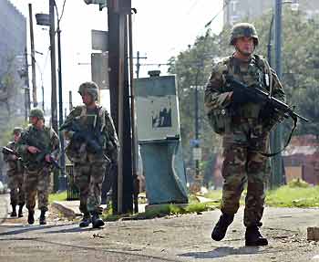 Military personnel patrol St. Charles Street in New Orleans, as evacuations of Hurricane Katrina continued on September 5, 2005. Thousands of families returned to their battered homes outside New Orleans on Monday to pick up the pieces left by Hurricane Katrina, and President George W. Bush promised support to aid recovery from a disaster in which aid efforts were bungled and 10,000 may have died.