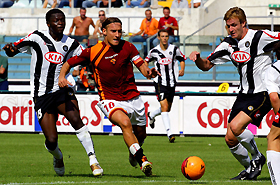 AS Roma's captain Francesco Totti (2nd L) fights for the ball with Udinese's Cesare Natali (R) and Sulley Ali Muntari (L) during their Italian Serie A soccer match at the Olympic Stadium in Rome, September 11, 2005. Udinese won the match 1-0.