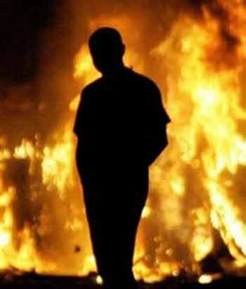 A Protestant youth passes a burning bus in north Belfast, Northern Ireland Monday Sept 12, 2005.