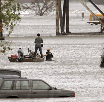 An unidentified camera crew makes its way by boat through the newly flooded Ninth Ward in New Orleans September 23, 2005. Texas officials warned of catastrophe and an already devastated New Orleans suffered renewed flooding as weakened levees gave way in the hours before Hurricane Rita's expected strike at the U.S. Gulf Coast. [Reuters]