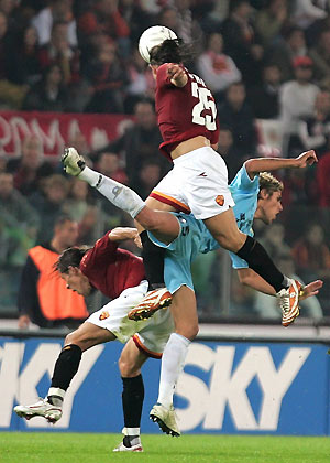 Roma's Rodrigo Ferrante Taddei (L) and Leandro Cufre' (top) challenges Lazio's Valon Behrami during their Serie A derby clash at the Olympic stadium in Rome October 23, 2005. 