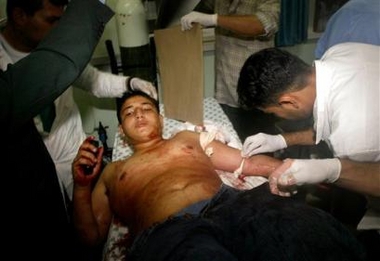 A Palestinian medic treats a wounded youth injured in an Israeli missile attack in Jebaliya, at the Kamal Edwan hospital in Beit Lahiya, northern Gaza Strip, Thursday, Oct. 27, 2005.