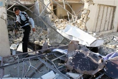 An Iraqi policeman steps over rubble of damaged homes, after a mortar round exploded in Baghdad, Iraq, Sunday, Nov. 13, 2005.