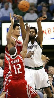 Minnesota Timberwolves center Michael Olowokandi, right, of Nigeria, passes under pressure from Houston Rockets center Yao Ming, left rear, of China, and guard Rafer Alston (12) during the first quarter in Minneapolis, Tuesday, Nov. 15, 2005.