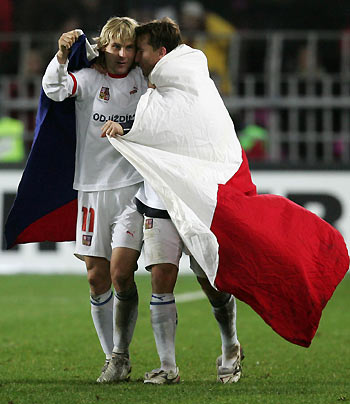 Czech soccer players Vladimir Smicer (R) and Pavel Nedved, wrapped up in a national flag, celebrate after the Czechs defeated Norway 1-0 at the World Cup 2006 second leg play-off match in Prague, November 16, 2005. 