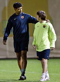 Frank Rijkaard from the Netherlands (L) talks to Argentinian player Lionel Messi before a training session at the Nou Camp stadium in Barcelona November 17, 2005.