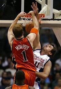 Golden State Warriors' Troy Murphy, top left, dunks over Los Angeles Clippers' Zelijko Rebraca, of Serbia-Montenegro, as Warriors' Michael Pietrus watches in the first half Sunday, Nov. 20, 2005, at Staples Center in Los Angeles.