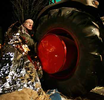 A farmer chains himself to the wheel of a tractor in the small village of Grippel late November 21, 2005, as they block the transport road to the Gorleben interim storage facility.