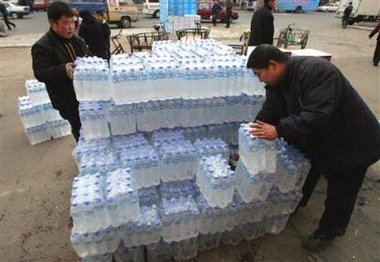 Workers stack bottled water on a roadside in Harbin, in northeast China's Heilongjiang province Thursday, Nov. 24, 2005. Authorities have shut down the city's water supply due to contamination of the Songhua river, from which Harbin gets its water, after an explosion in a chemical plant in a city up river. [AP]